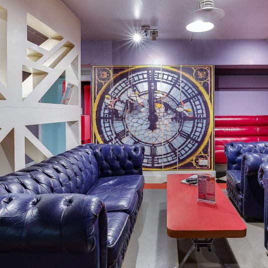 A social space at Clink 261 hostel in London with purple couches