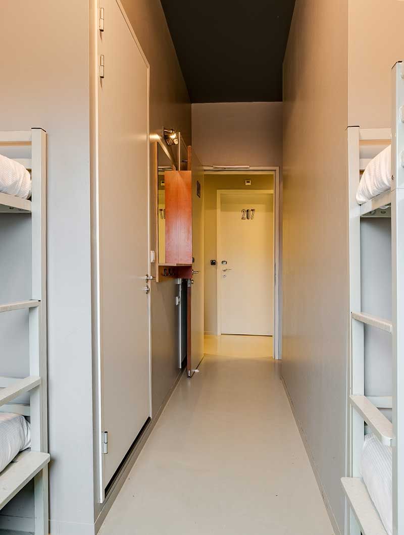 Ein Schlafsaal im ClinkNOORD Hostel in Amsterdam mit Blick auf den Korridor 