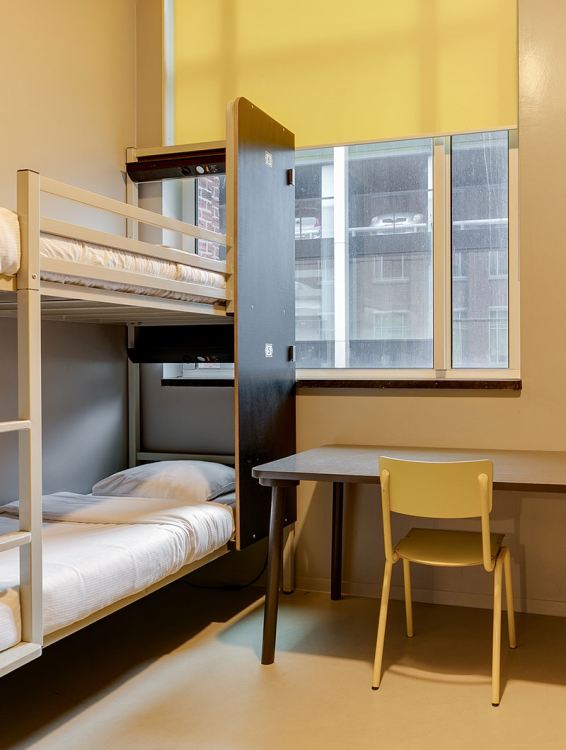 Bunk beds, a desk and a chair in a private room at ClinkNOORD hostel in Amsterdam