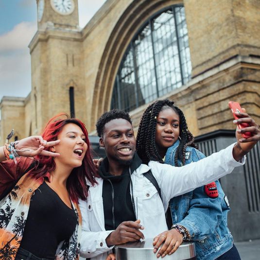 Tourists enjoying their travelling experiences in London, taking a selfie
