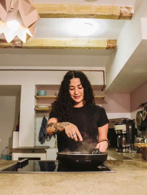 a guest cooking at clinkcoco hostel in amsterdam