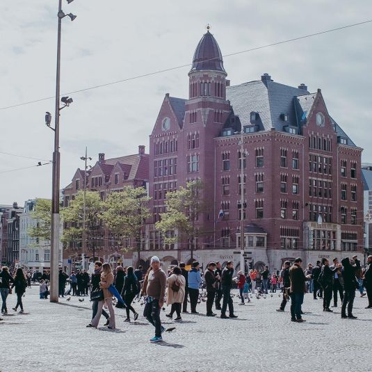 Turistas e peões reunidos na Praça Dam, em Amesterdão