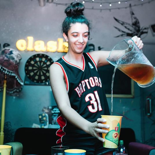 A guest at the Clash Bar in Clink 78 pouring a drink from a pitcher