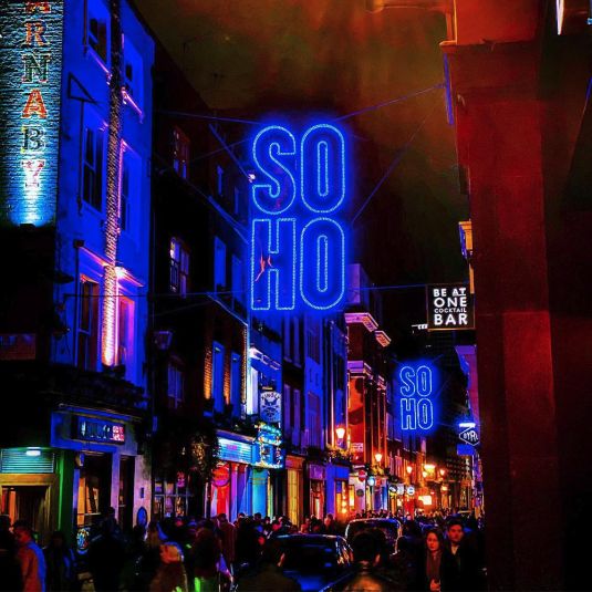 People gather at the bars and clubs at nighttime in London's Soho borough