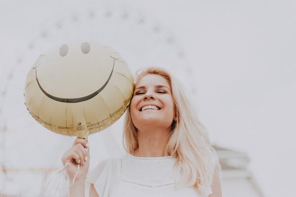 happy woman with a smiley balloon