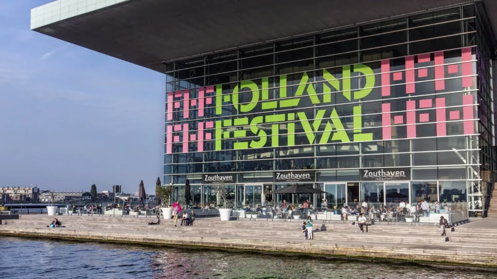 Large Holland Festival sign in sunshine beside the river