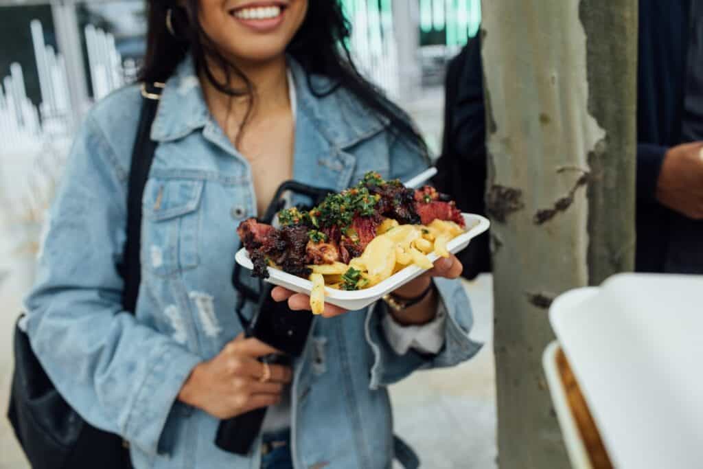 Woman holding a tray of street food