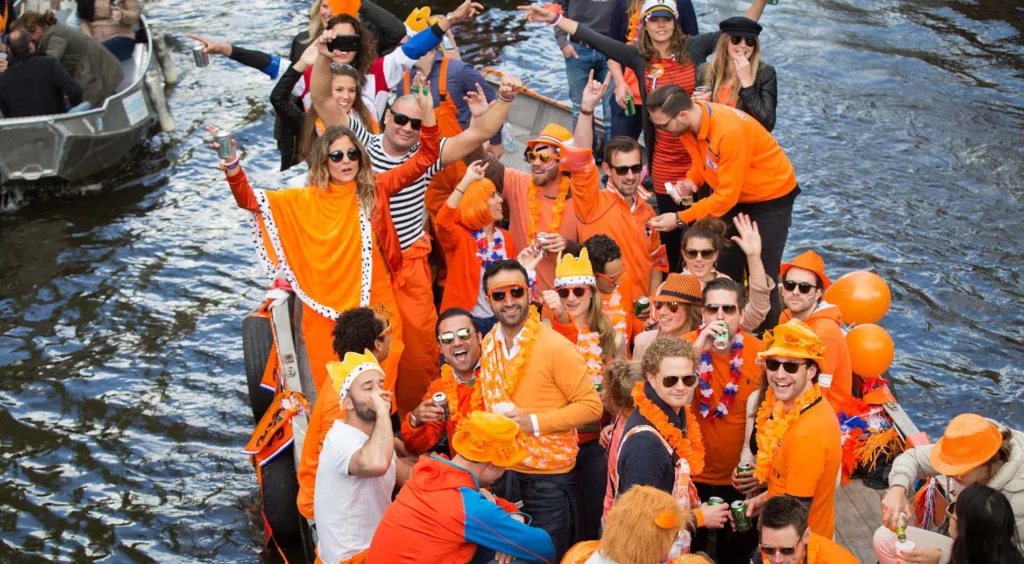 People on a boat dressed in orange for King's Day in Amsterdam