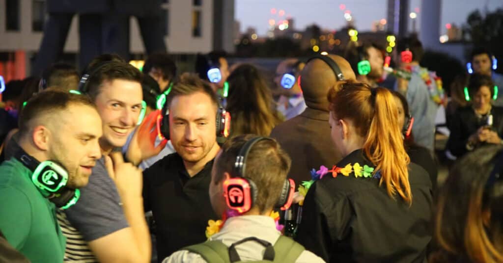 Group of people wearing lit up headphones at Silent Sounds Boat Party