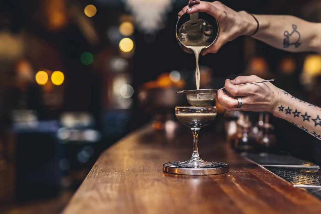 a bartender crafts an espresso martini in a London cocktail bar