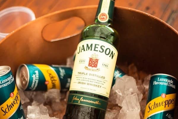 Bottle of Jameson in a bucket with ice and Schweppes