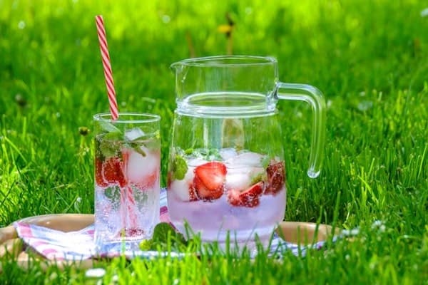 Strawberry drink in jar and glass in a park