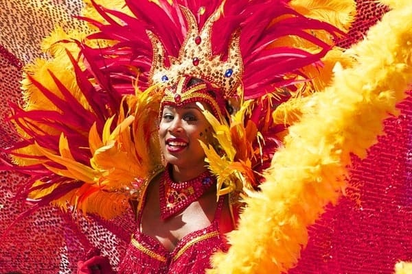 Woman wearing a red and yellow feather costume for the Notting Hill Carnival in London